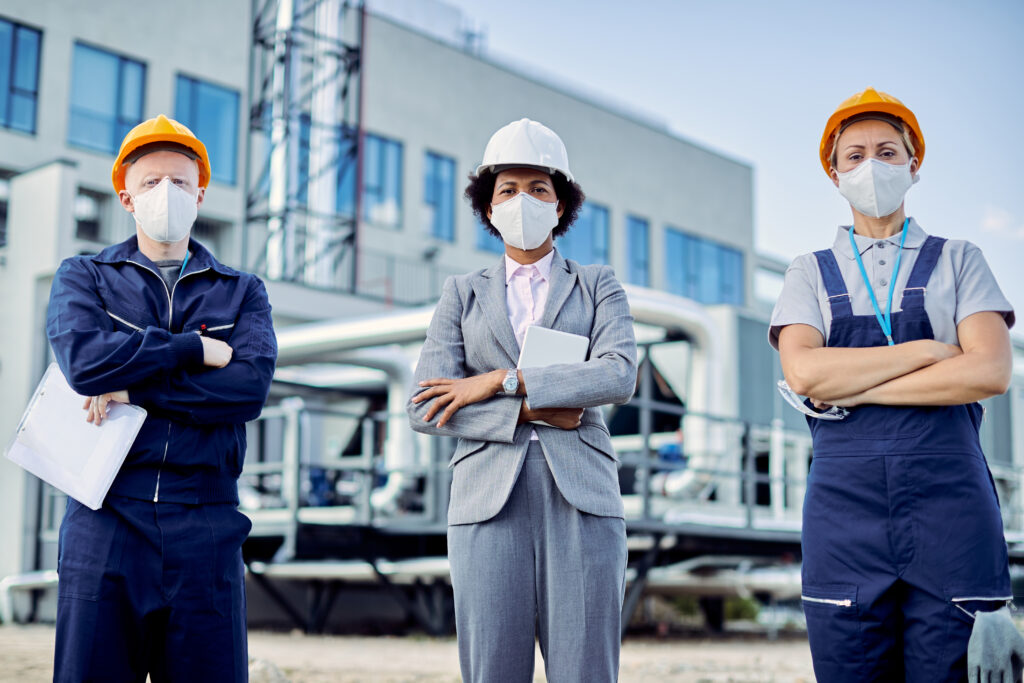 team confident civil engineers with protective face masks construction site