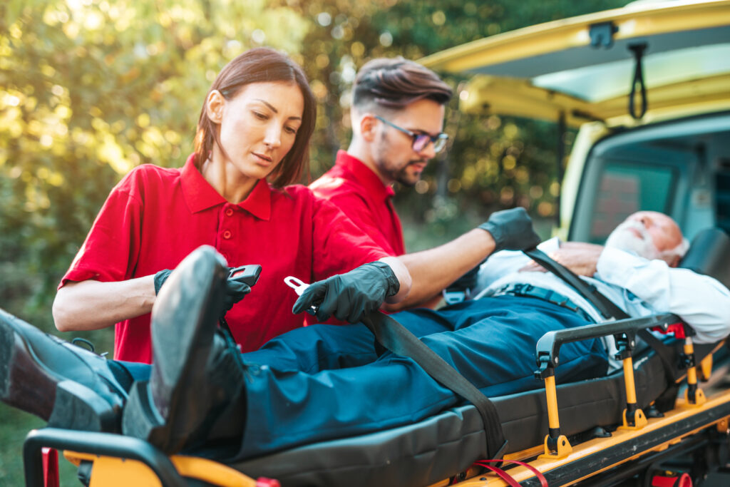 emergency medical service work paramedic is pulling stretcher with senior man with serious heart attack ambulance car help road drivers assistance concept